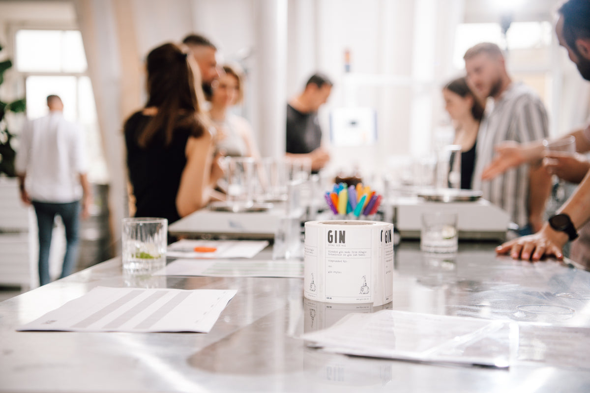 Gin Workshop in Basel, Teilnehmende an langen Tischen mit Botanical-Destillaten