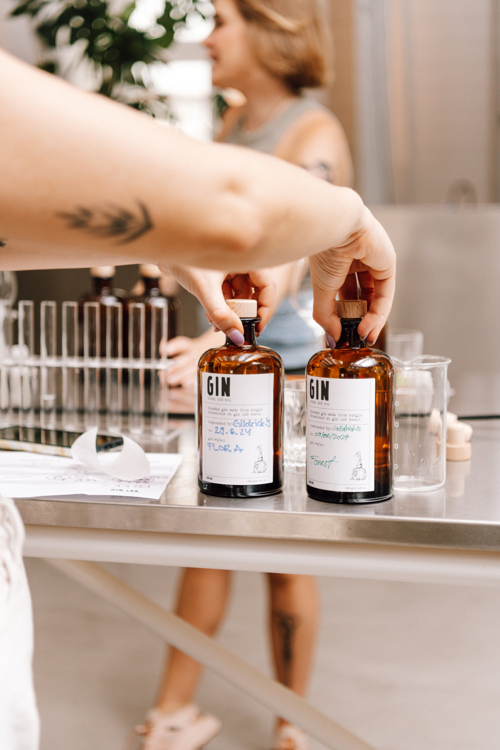 Zwei fertige, von Hand beschriftete Gin-Flaschen aus dem Workshop