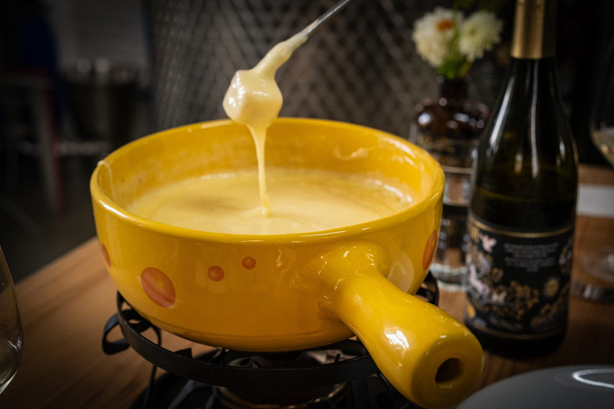 Käsefaden über dem Caquelon beim Gin Fondue im GIN LAB Basel